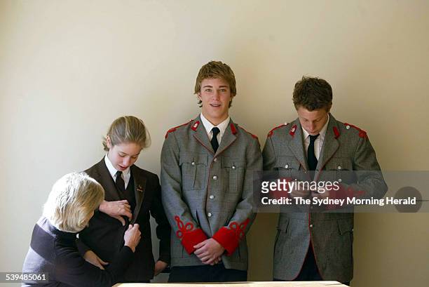 Ellie Scott buttons the Frensham blazer of her daughter Katie. Her sons Jamie and John are in the King's School uniform, 25 July 2004. SMH Picture by...