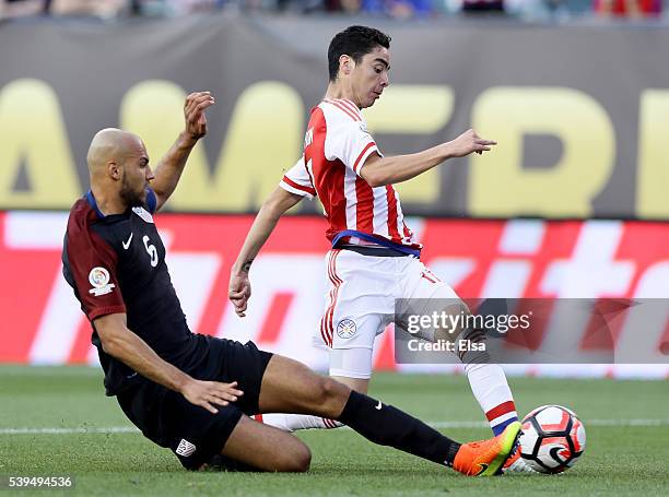 Miguel Almiron of Paraguay tries to keep the ball as John Brooks of United States slides in the first half during the Copa America Centenario Group C...