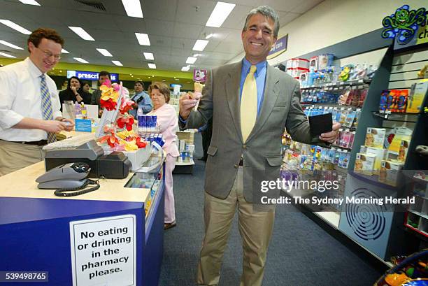 Deputy Prime Minister John Anderson inside a pharmacy on 8 September 2004,with a sign reading no eating or drinking in the pharmacy please with a rum...