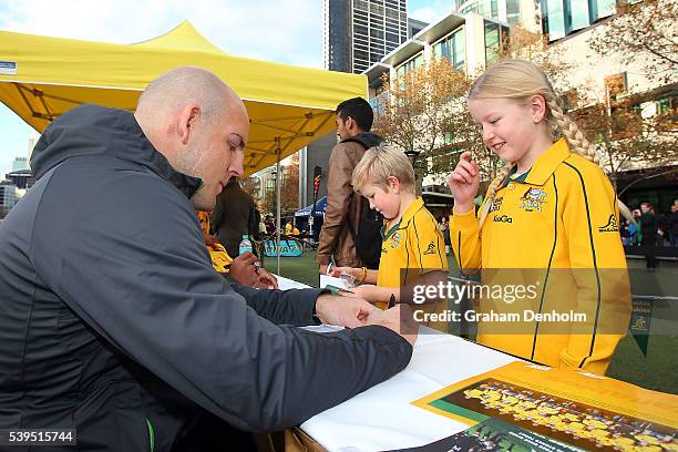 Stephen Moore of the Wallabies signs his autograph for a young fan during the Australian Wallabies Fan Day at The Crown Promenade River Walk on June...