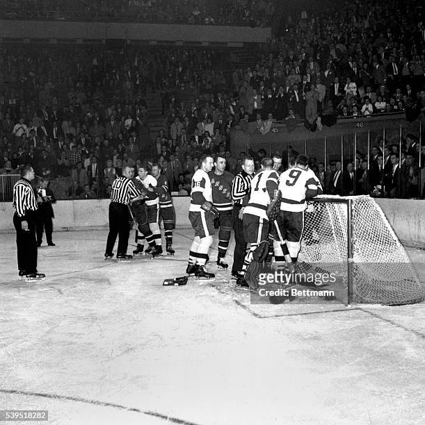 Gordie Howe shown standing by as linesman, Ant Skov restrains Lou Fortinato of the Rangers after they had a fight during the game.
