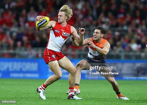 James Rose of the Swans is tackled by Stephen Coniglio of the Giants during the round 12 AFL match between the Greater Western Sydney Giants and the...