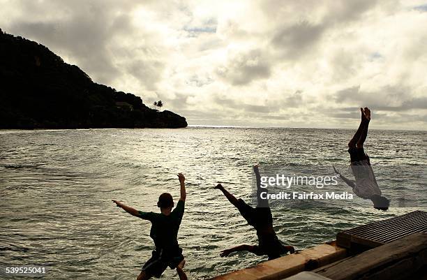 Children jump off the Flying Fish Cove jetty at Christmas Island.