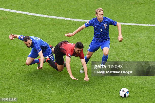 Hakan Calhanoglu of Turkey competes for the ball against Milan Badelj and Ivan Strinic of Croatia during the UEFA EURO 2016 Group D match between...