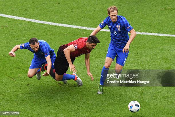 Hakan Calhanoglu of Turkey competes for the ball against Milan Badelj and Ivan Strinic of Croatia during the UEFA EURO 2016 Group D match between...