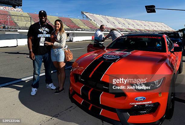 Player Antwione Williams of the Detroit Lions and guest pose with the pace car before the NASCAR Sprint Cup Series FireKeepers Casino 400 at Michigan...