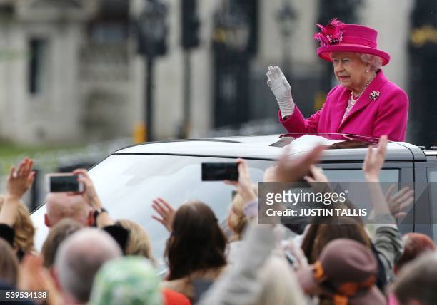 Britain's Queen Elizabeth II waves to guests as she visits the Patron's Lunch, a special street party outside Buckingham Palace in London on June 12...