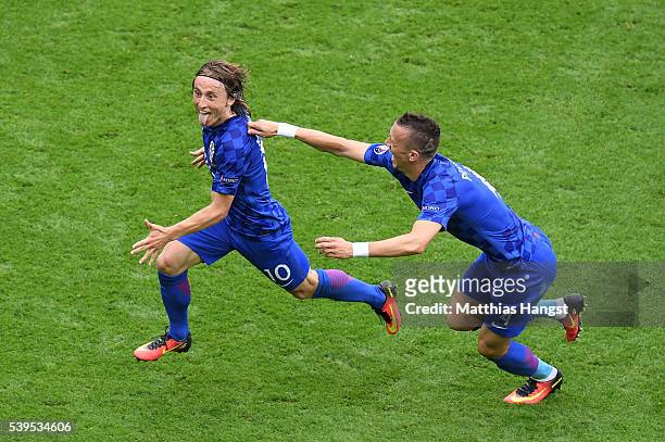 Luka Modric of Croatia celebrates scoring his team's first goal with his team mate Ivan Perisic during the UEFA EURO 2016 Group D match between...