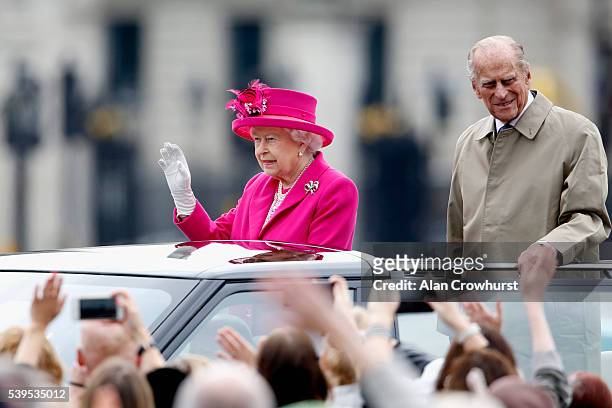 Queen Elizabeth II and Prince Philip, Duke of Edinburgh wave to guests during "The Patron's Lunch" celebrations for The Queen's 90th birthday at on...