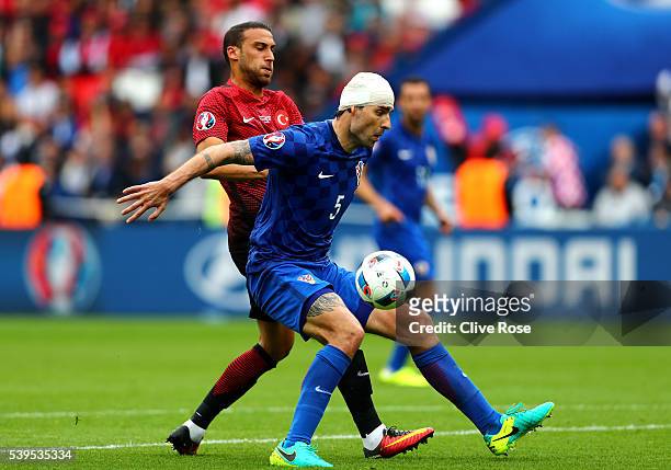 Vedran Corluka of Croatia controls the ball under pressure of Cenk Tosun of Turkey during the UEFA EURO 2016 Group D match between Turkey and Croatia...