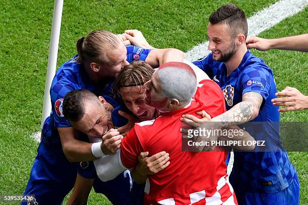 Fan enters onto the pitch to celebrates with Croatia's midfielder Luka Modric and his teammates after Modric scored the team's first goal during the...