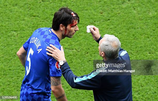 Vedran Corluka of Croatia receives medical treatment during the UEFA EURO 2016 Group D match between Turkey and Croatia at Parc des Princes on June...