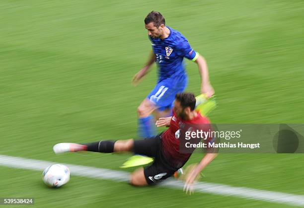 Darijo Srna of Croatia and Hakan Calhanoglu of Turkey compete for the ball during the UEFA EURO 2016 Group D match between Turkey and Croatia at Parc...