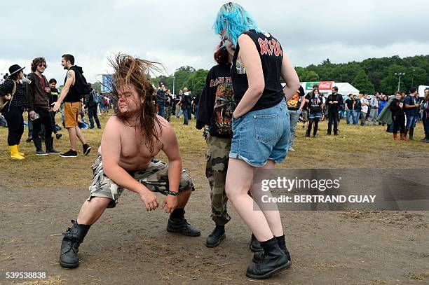 Participants dance during the hard rock music Download festival in Paris on June 12, 2016. Download Festival gathers in the UK since 2003 fans of...