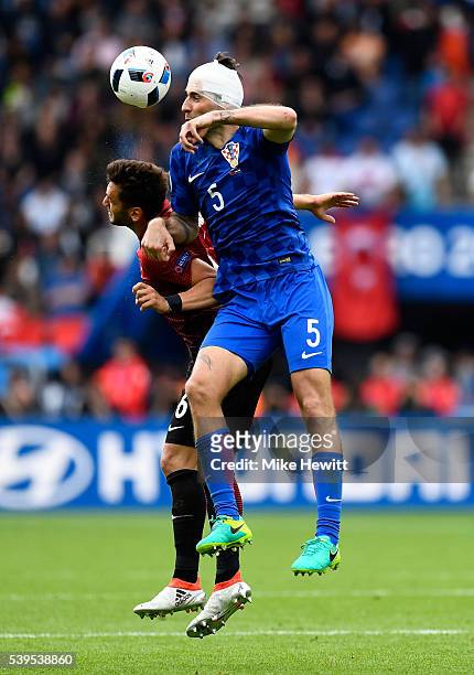 Vedran Corluka of Croatia and Hakan Calhanoglu of Turkey compete for the ball during the UEFA EURO 2016 Group D match between Turkey and Croatia at...