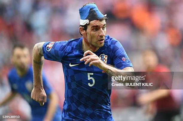 Croatia's defender Vedran Corluka plays with a bandaged head following an injury during the Euro 2016 group D football match between Turkey and...