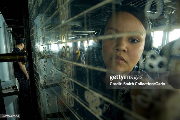 Operations Specialist Seaman Lorraine Cervantes writes on the status board in the pilothouse aboard the US 7th Fleet flagship USS Blue Ridge LCC 19...