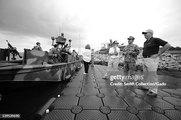 Commander Peter Berning, chief staff officer for Riverine Group 1, explains the mission and capabilities of Riverines to members of the Michigan...