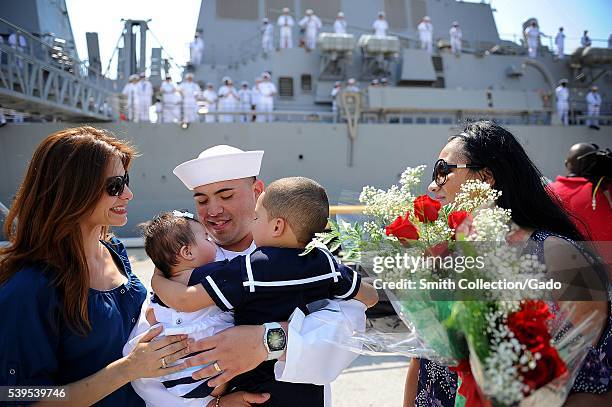 Ship's Serviceman 3rd Class Robert Gomez, assigned to the Arleigh Burke-class guided-missile destroyer USS The Sullivans DDG 68, sees his newborn...