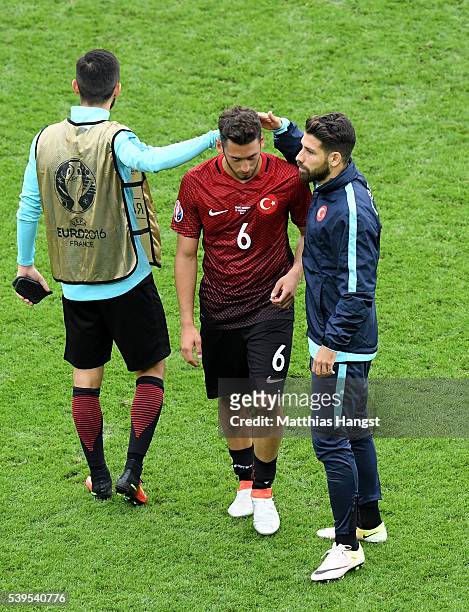 Hakan Calhanoglu of Turkey is consoled by his team mates after their team's 0-1 defeat in the UEFA EURO 2016 Group D match between Turkey and Croatia...