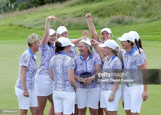 The Great Britain and Ireland team celebrate with the Curtis Cup trophy after they had secured a match total 11.5 to 8.5 victory in the final day's...