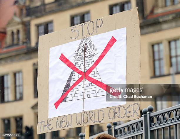 Protester's sign reads "Stop The New World Order" near the venue of the 2016 Bilderberg Group conference on June 12, 2016 in Dresden, Germany....