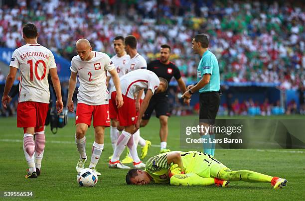 Wojciech Szczesny of Poland lies on the pitch after colliding with his team mate Lukasz Piszczek during the UEFA EURO 2016 Group C match between...