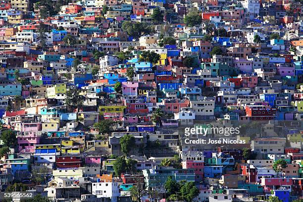 In Haiti's Jalousie slum, workers have begun painting the concrete facades a rainbow of purple, peach, lime and cream, inspired by the dazzling...