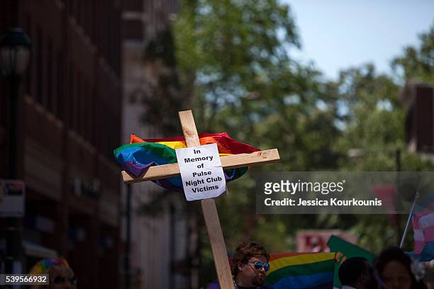 Austin Ellis, a member of Metropolitan Community Church, carries a cross with a sign in memory of the victims of the Pulse nightclub shooting as he...