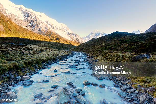 a landscape shot of a flowing river from melting ice. - new zealand snow stock-fotos und bilder