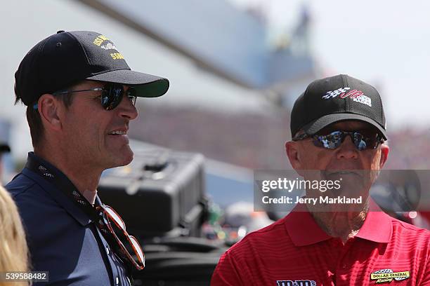 University Of Michigan football coach Jim Harbaugh talks to team owner and former NFL coach Joe Gibbs during the NASCAR Sprint Cup Series FireKeepers...