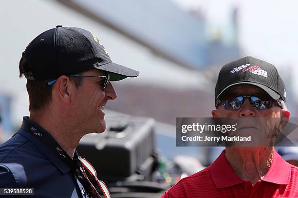 University Of Michigan football coach Jim Harbaugh talks to team owner and former NFL coach Joe Gibbs during the NASCAR Sprint Cup Series FireKeepers...