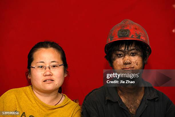 Coal miner with work clothes and his wife poses for photography at a coal mine in Huaibei city, Anhui province, 26th April 2015. Liang Su , male,...