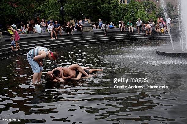 Two drunk fraternity 'brothers' wrestle in the Washington Square Park's fountain.