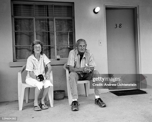 Couple sit outside of their motel room in Cherokee, North Carolina, on the Cherokee Indian Reservation. Many tourists come to visit the area to...