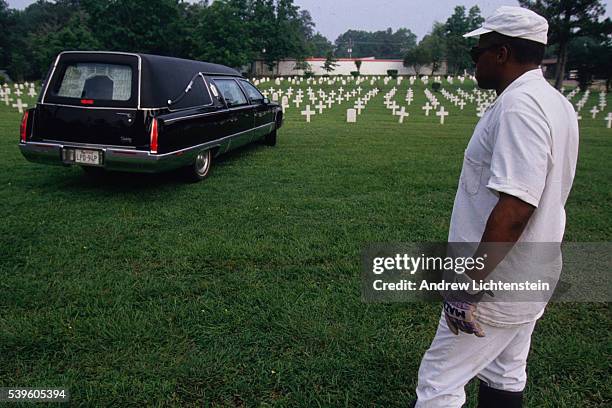 Texas prisoner working as a grave digger waits for a hearst to drop off the casket of a prisoner executed at the Walls Unit, in July at the Joe Byrd...