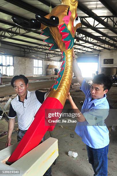 Workers produce dragon boats for racing , which is one of a traditional festival content Duanwu for memory Poet Quyuan fall on lunar May 5th, in a...