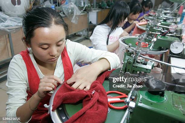 Workers sew sweaters at a workshop of a textile factory in Taiyuan, Shanxi province September 1, 2009. VCP