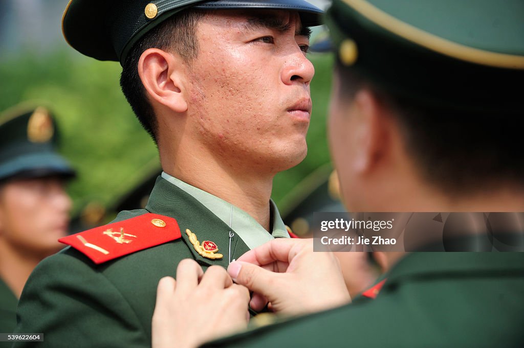 An officer sticks a needle in the collar of a paramilitary policeman to correct his posture during a training session in