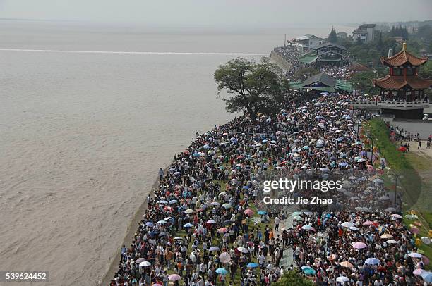 Visitors gather to watch the soaring tide on the bank of Qiantang River in Haining, Zhejiang province, October 6, 2009. The most violent tidal waves...