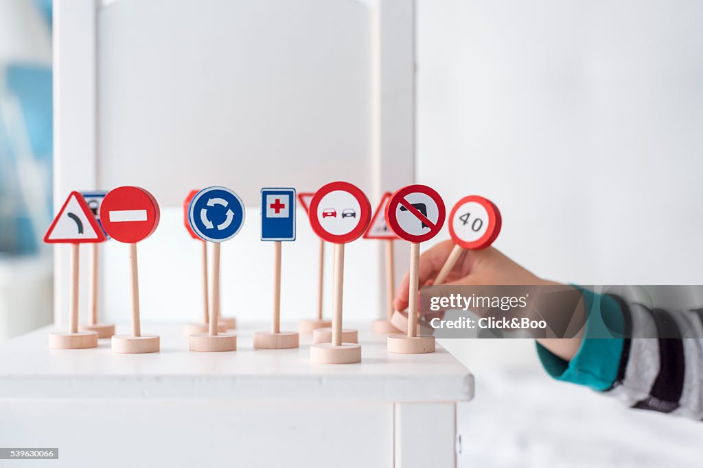 A boy placing toy traffic signs