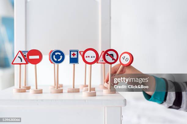 a boy placing toy traffic signs - spelregels stockfoto's en -beelden