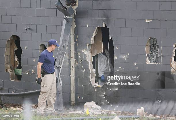 Agents investigate the damaged rear wall of the Pulse Nightclub where Omar Mateen allegedly killed at least 50 people on June 12, 2016 in Orlando,...
