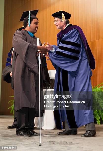 Blind student participates in graduation festivities at the Lyndon Baines Johnson School of Public Affairs. Approximately 108 students received their...