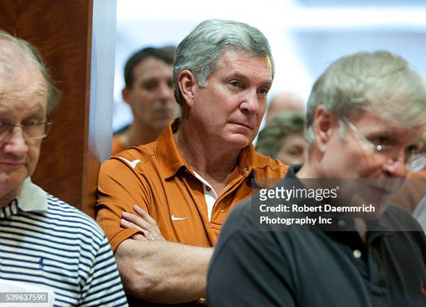 University of Texas football coach Mack Brown listens to the press conference where UT President Bill Powers talks about Texas' reasons for staying...