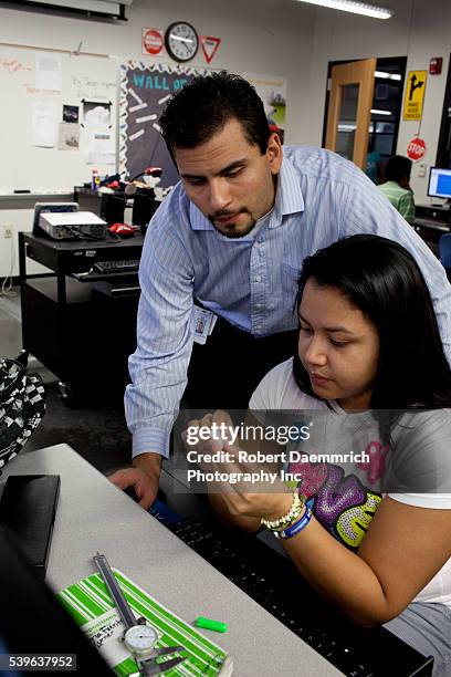 Freshman engineering student is aided by a teacher using computer-aided design to duplicate parts specifications for household items at the Math,...
