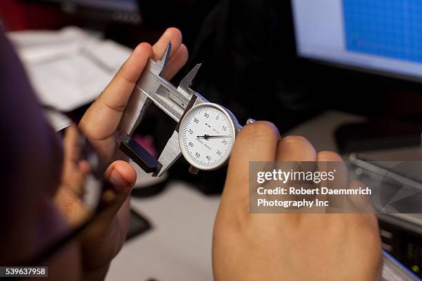 Freshman engineering students using computer-aided design and precision micrometers to duplicate parts specifications for household items at the...