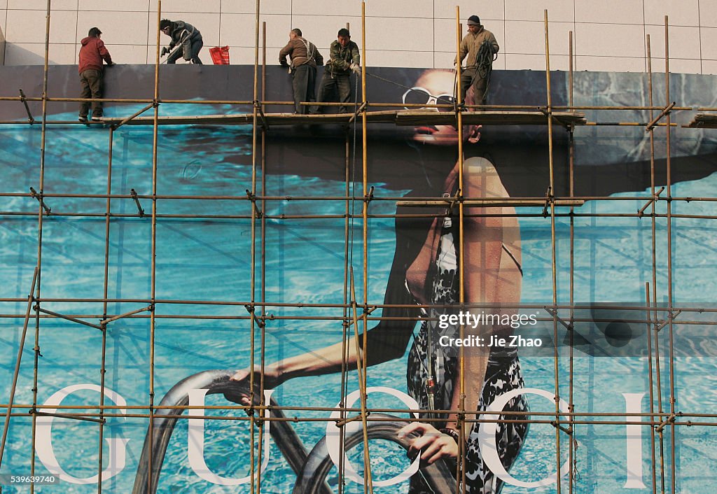 Labourers fix an advertising board on a street in Taiyuan, Shanxi province