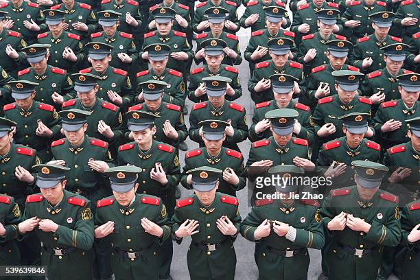 Recruits of the paramilitary police adjust their uniforms during a rank-greated ceremony at a military base in Suining, Sichuan province February 5,...