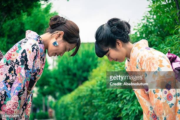 beautiful japanese women in kimono bowing, kyoto, japan - buga bildbanksfoton och bilder